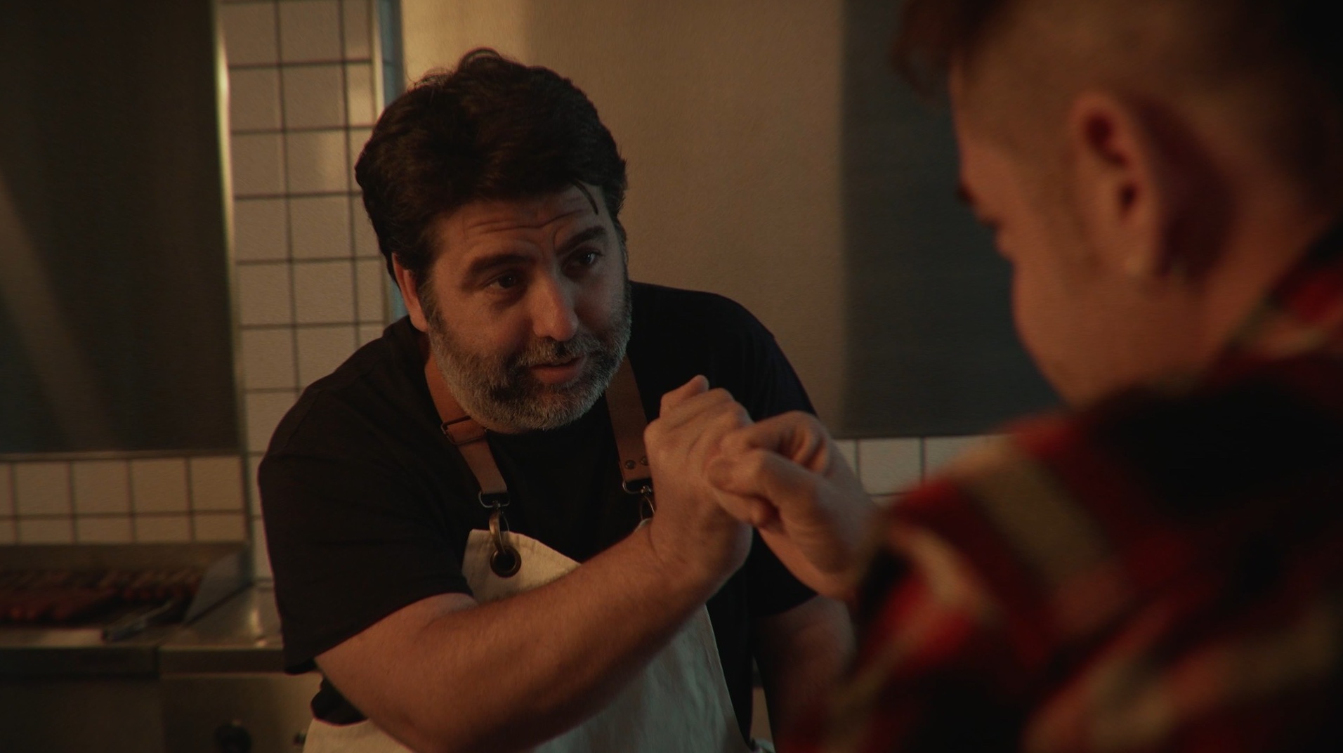 Cocinero con delantal saluda al cliente con un apretón de manos